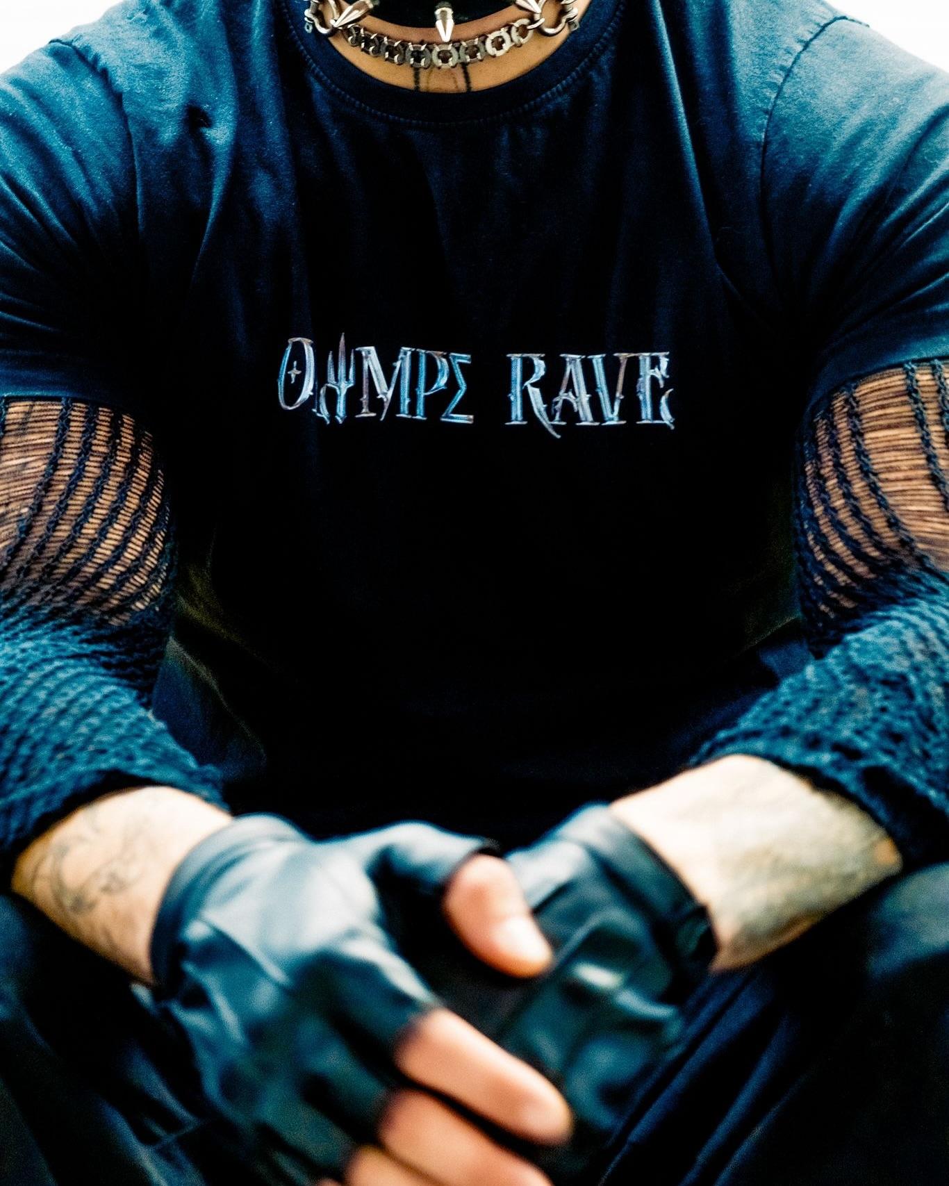 Close-up of an OLYMPE RAVE T-shirt worn with mesh sleeves and fingerless gloves